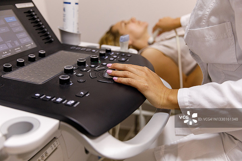 女超声医师在甲状腺检查期间操作超声机器图片素材