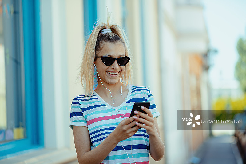 夏天在户外使用手机的少女图片素材