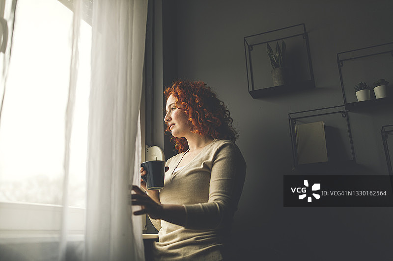 向窗外看，一边沉思一边品味咖啡图片素材