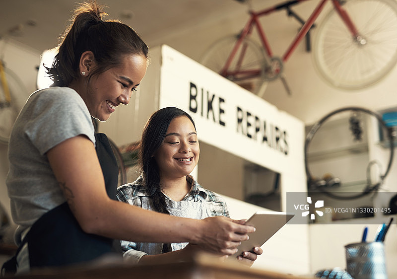 两名年轻女子在工作中使用平板电脑的照片图片素材
