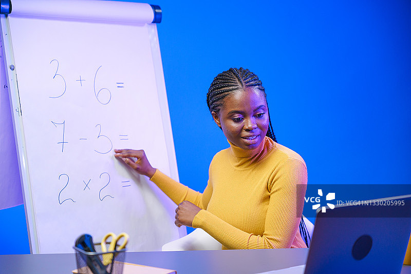 可爱的深色皮肤年轻女教师在专业工作室录制在线课程图片素材