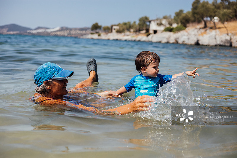 祖母和她的孙子在海里游泳图片素材