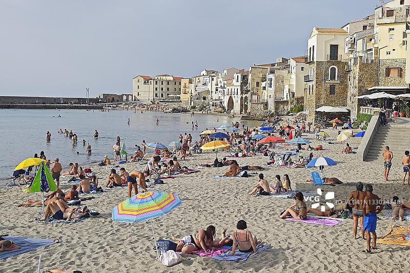 意大利西西里岛切法卢老城海滩上的沐浴者图片素材