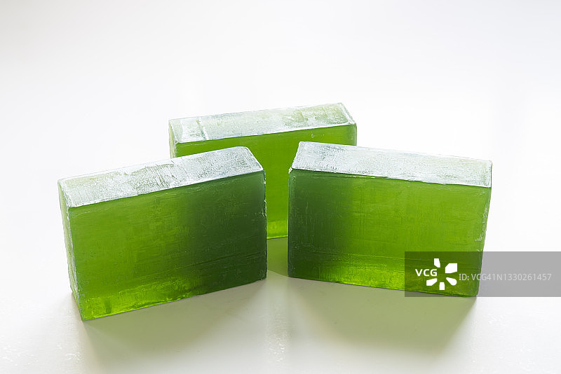 三块自制绿色甘油皂，白色背景图片素材