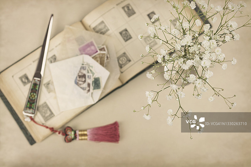 老邮票相册、开信刀和白色满天星图片素材