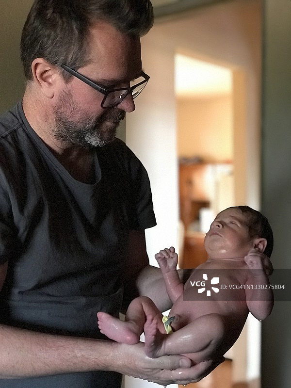 父亲给新生儿子洗澡图片素材