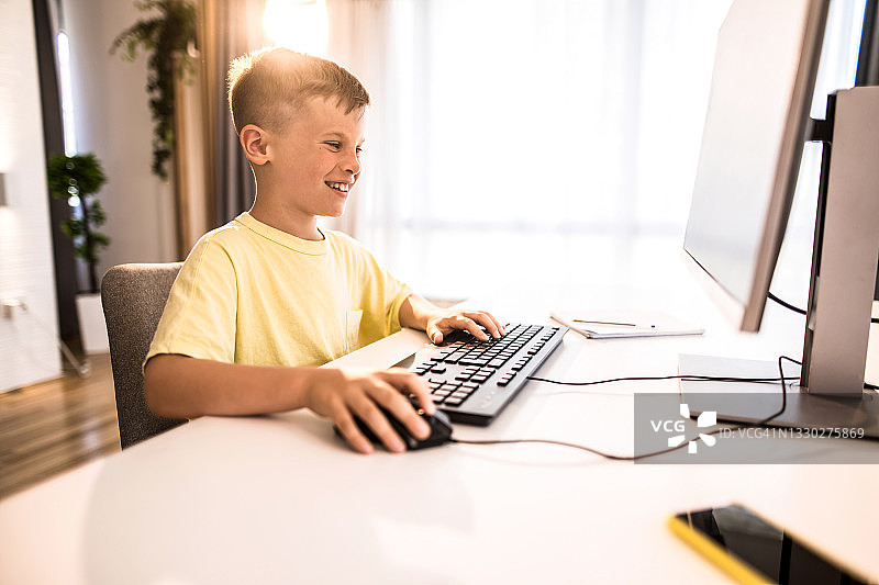 在家用电脑学习的聪明孩子图片素材