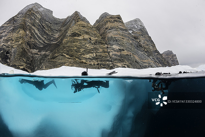 格陵兰东部峡湾中冰山和潜水员的分割景观图片素材