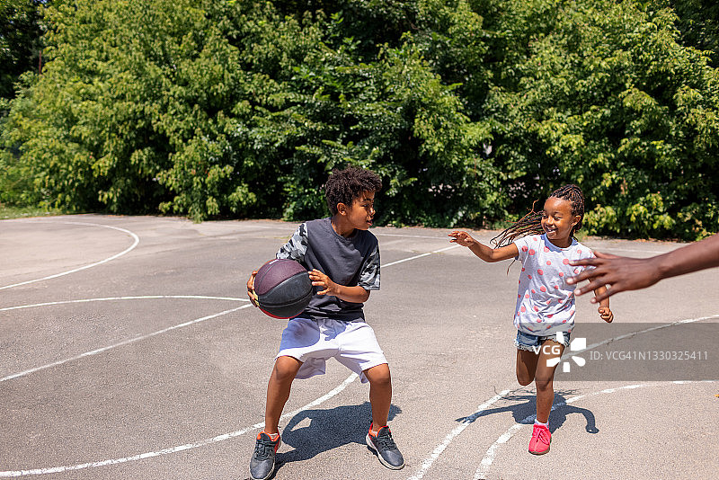 两个黑人小孩在户外打篮球图片素材