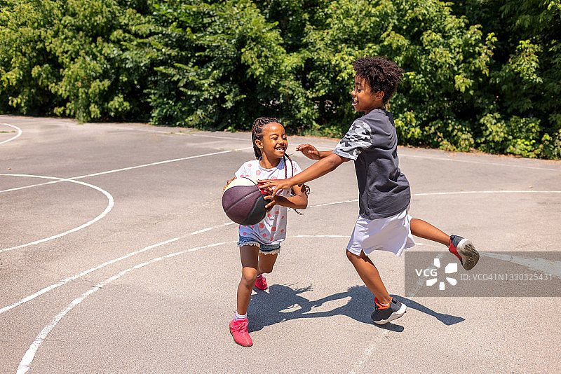 两个黑人小孩在户外打篮球图片素材