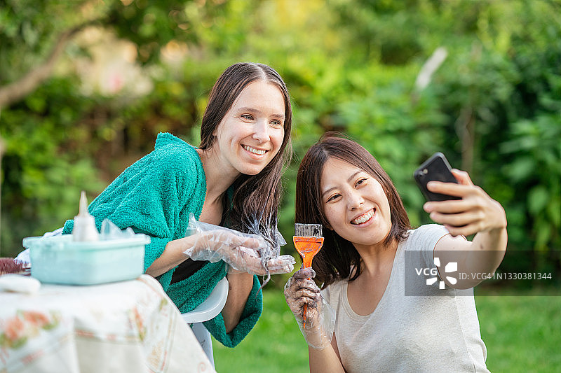 年轻女人在后院为朋友染发图片素材