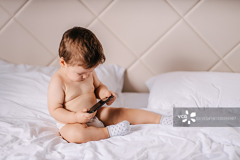 宝宝看着智能手机图片素材