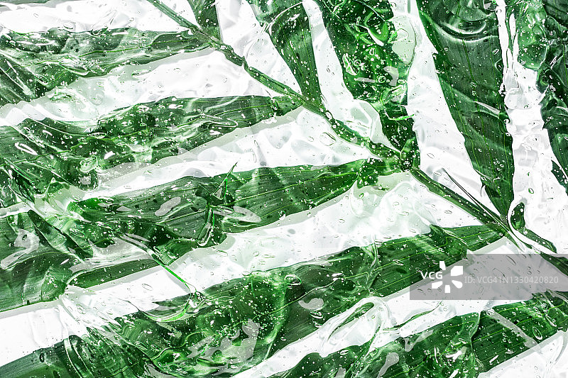 含气泡的抗菌芦荟凝胶，透明面部精华液涂抹在绿叶上，补水透明质酸，护肤化妆品，美容图片素材