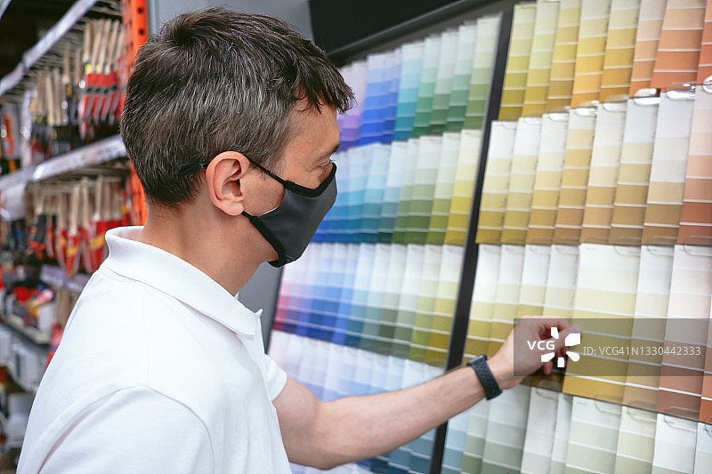 男人查看房屋改造的油漆样本图片素材