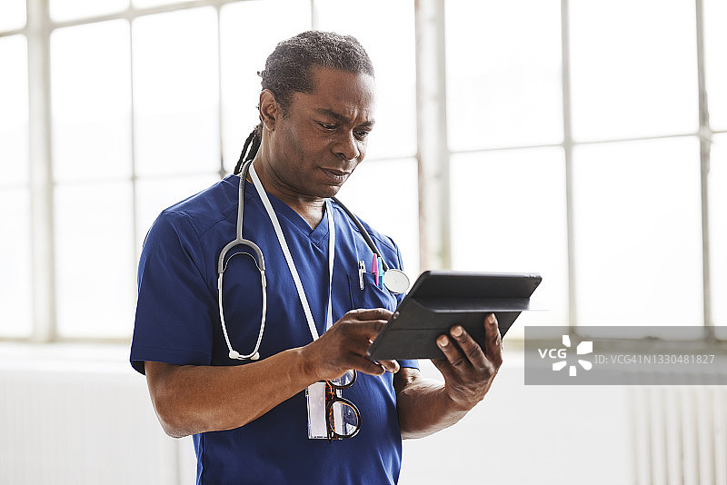 穿着手术服阅读电子病历的医生图片素材