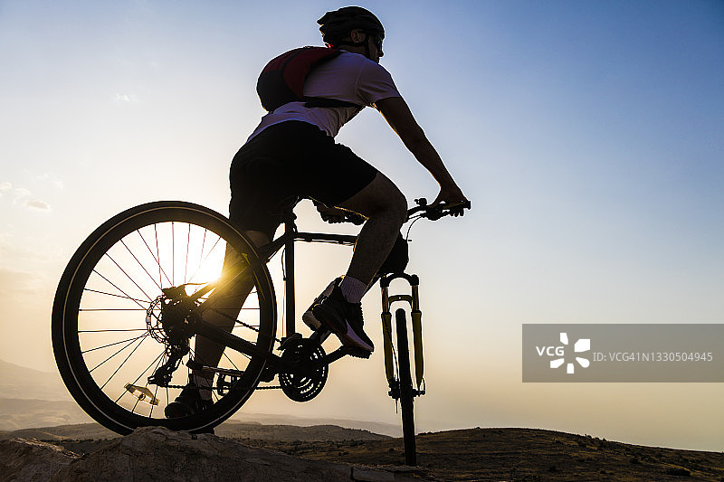 在日落时分进行山地自行车探险的骑行者图片素材