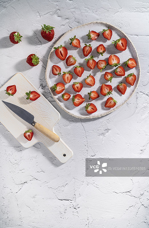 白色盘子上切半的草莓果实，乡村风格背景图片素材