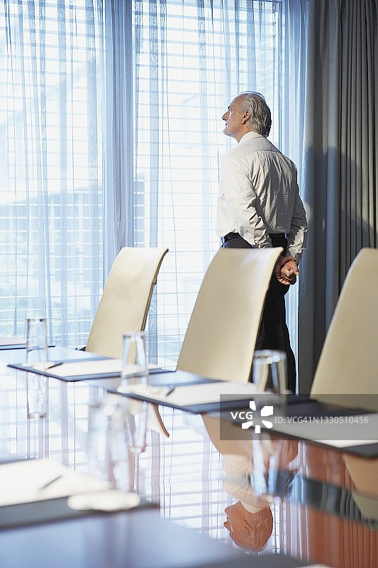 年长的商人在会议室里向窗外看去图片素材