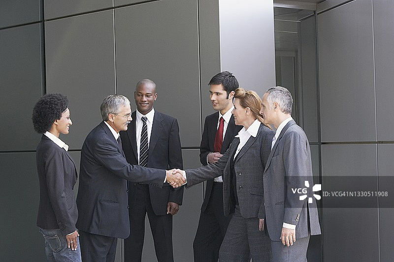 商务人士在办公楼外握手图片素材
