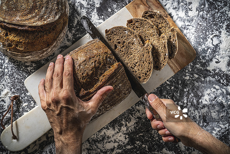 男人手切德国风味全麦自制酵母面包片图片素材