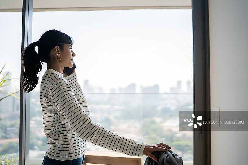 年轻女子在酒店房间里打电话图片素材