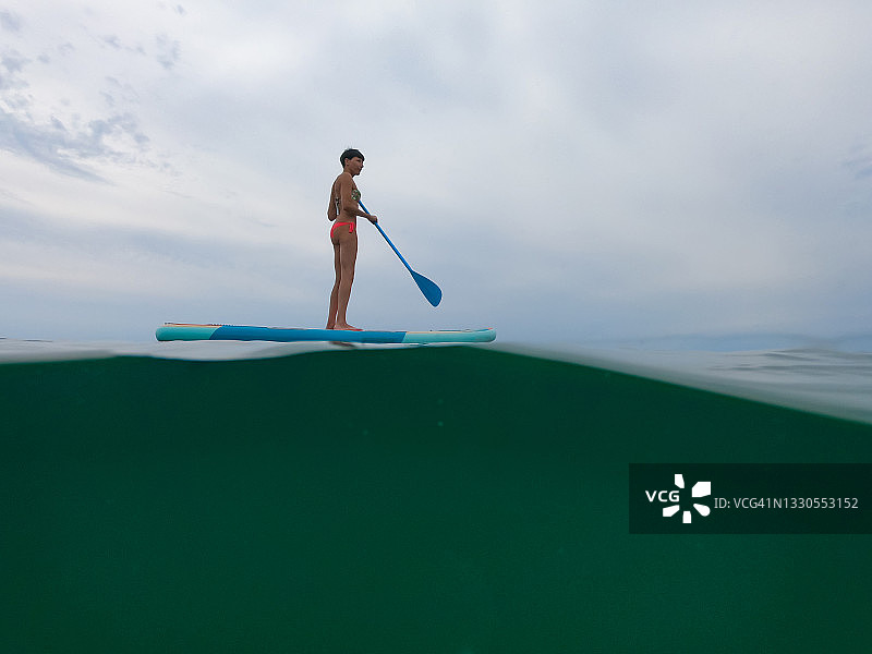 早晨划桨的女人的侧视图图片素材