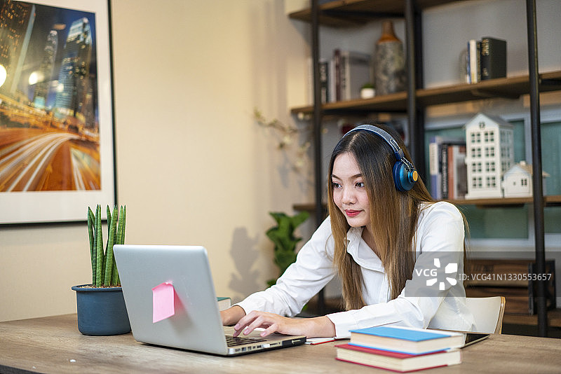 戴着耳机在家上网课的少女图片素材