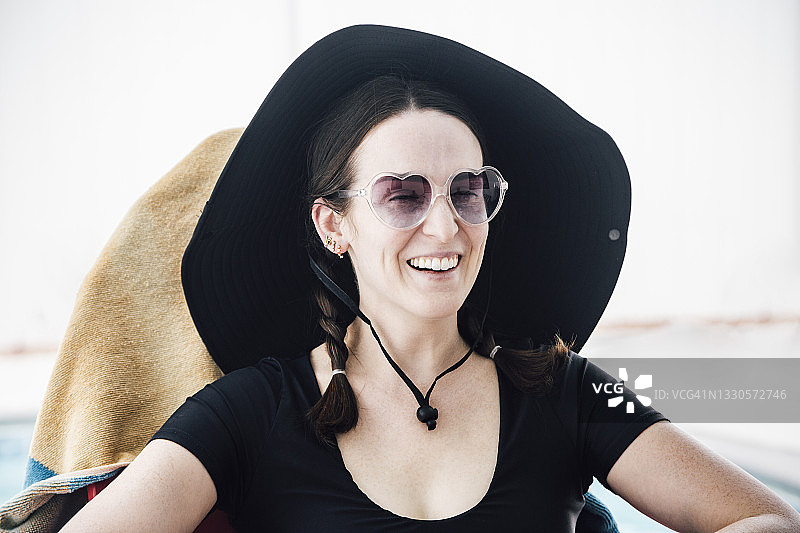 快乐美丽的女人在露台上眺望远方图片素材