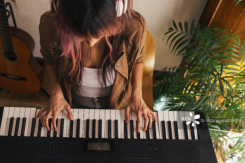年轻女子在家弹钢琴图片素材