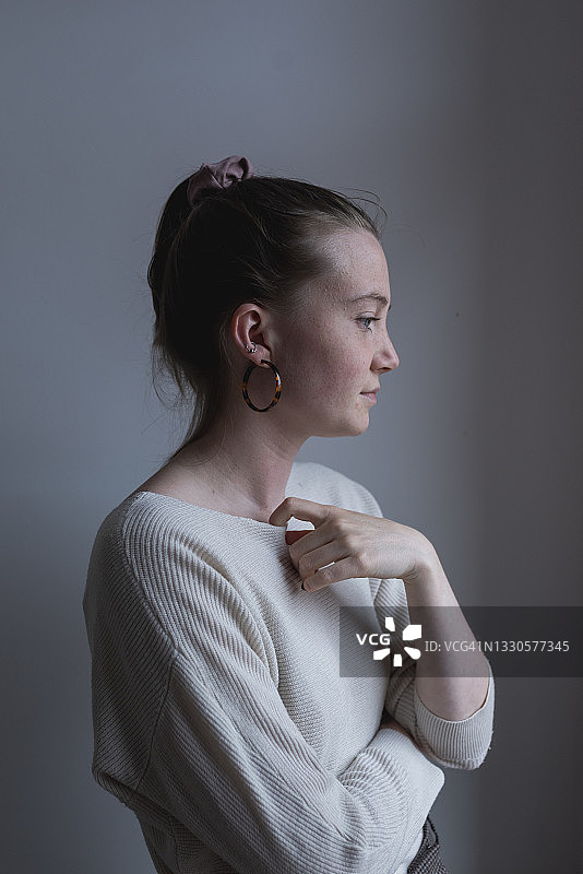 年轻女人站在家中的白墙边图片素材