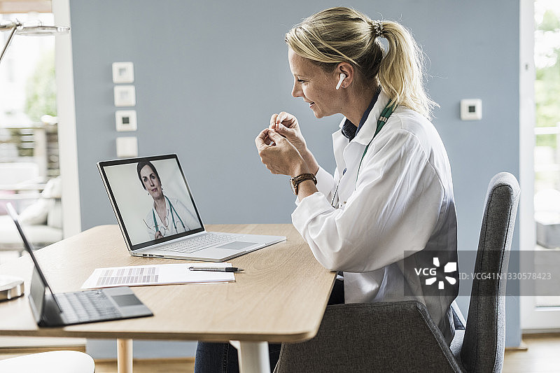 在办公室，职业女性通过笔记本电脑与同事进行视频通话图片素材