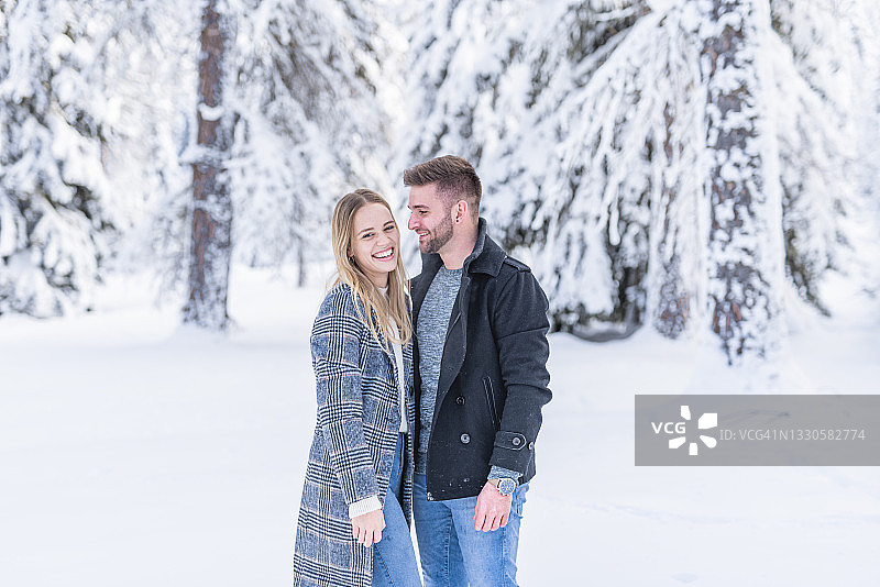 微笑的夫妇在冬季的雪地里图片素材