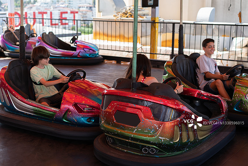 少年朋友们在碰碰车上玩耍图片素材