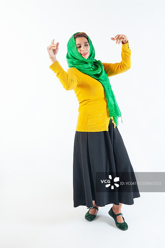 一位头戴头巾、穿着优雅的快乐女人在跳舞或庆祝图片素材