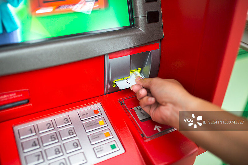 男子在ATM机上使用信用卡图片素材