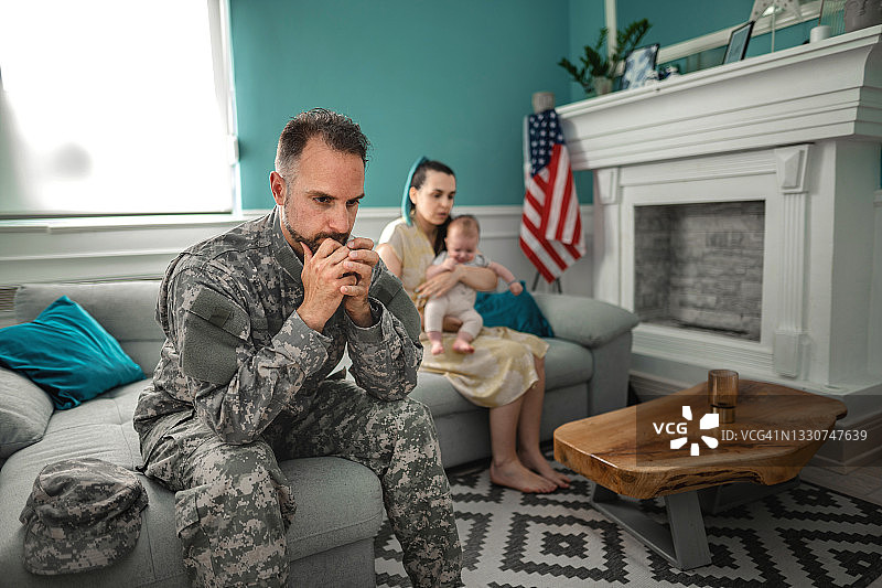 沮丧的士兵和家人一起坐在沙发上图片素材