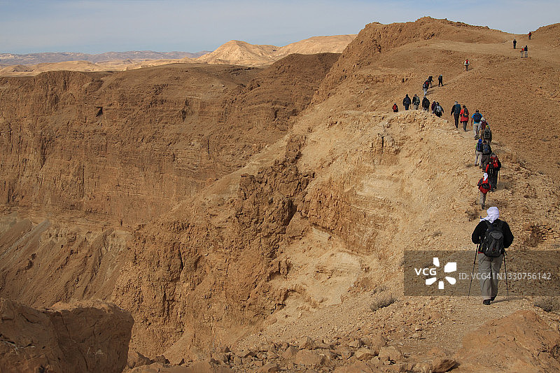 徒步者，老年人在峡谷陡峭的墙壁上的小路上徒步图片素材