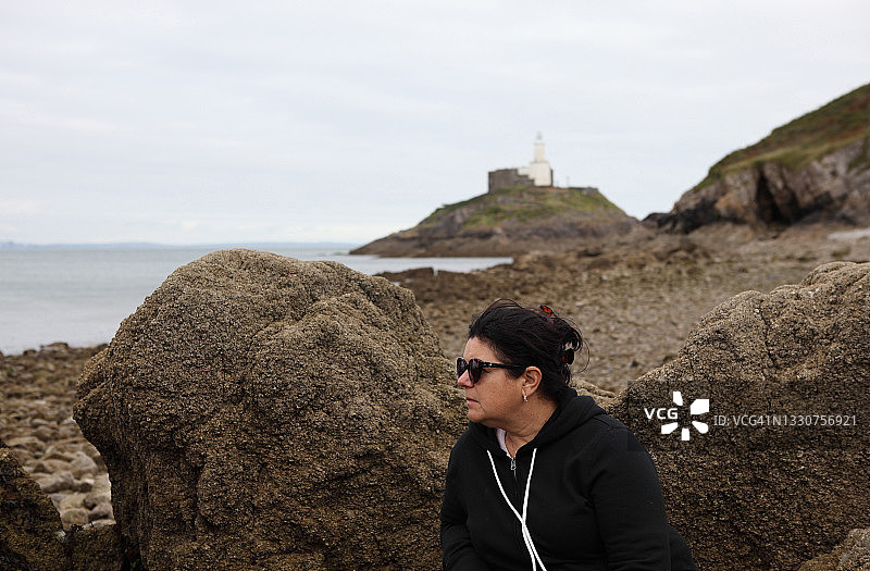 一位58岁女人坐在芒布尔斯岩石旁的个人资料图片素材