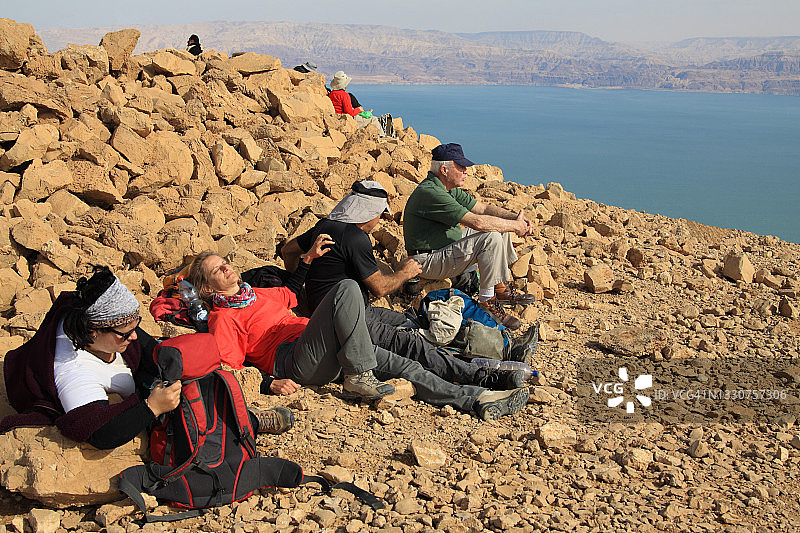 徒步旅行者在隐基底和裂谷死海上方休息时喝咖啡图片素材