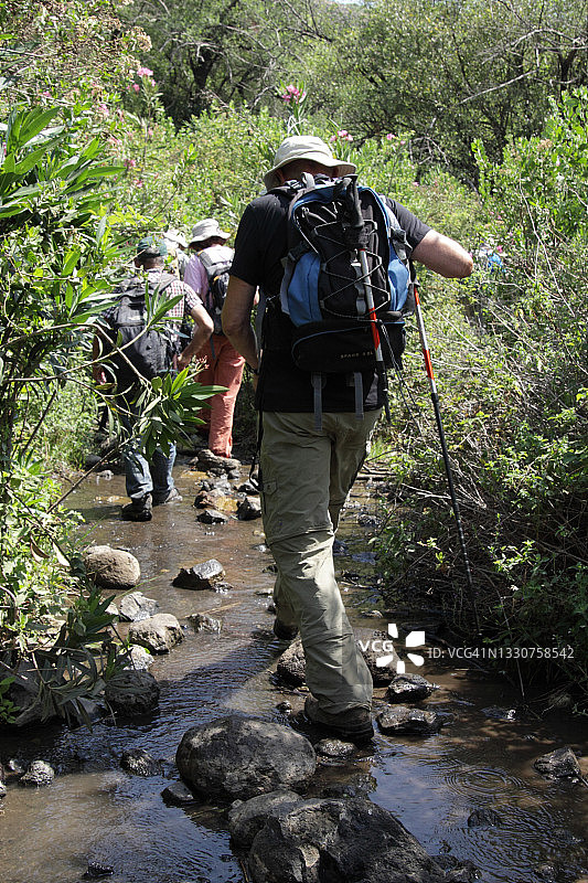 老人，徒步旅行者走在纳恰尔亚汶埃尔的鹅卵石上图片素材