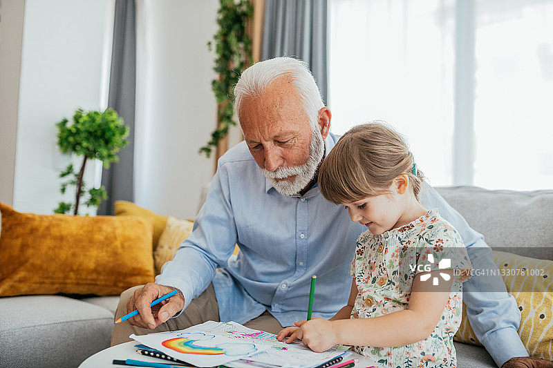 年长的男人和孙辈一起绘画，安享退休生活图片素材
