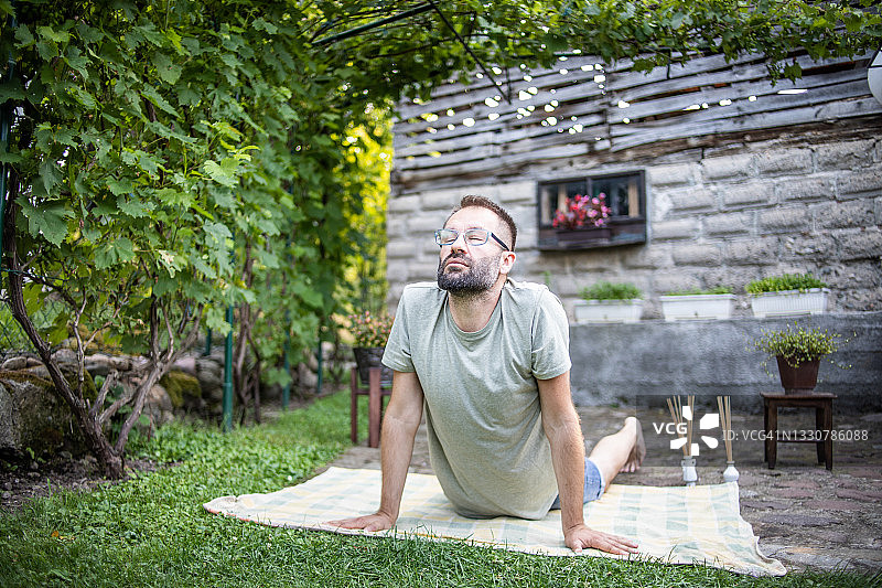 男子在后院做瑜伽图片素材