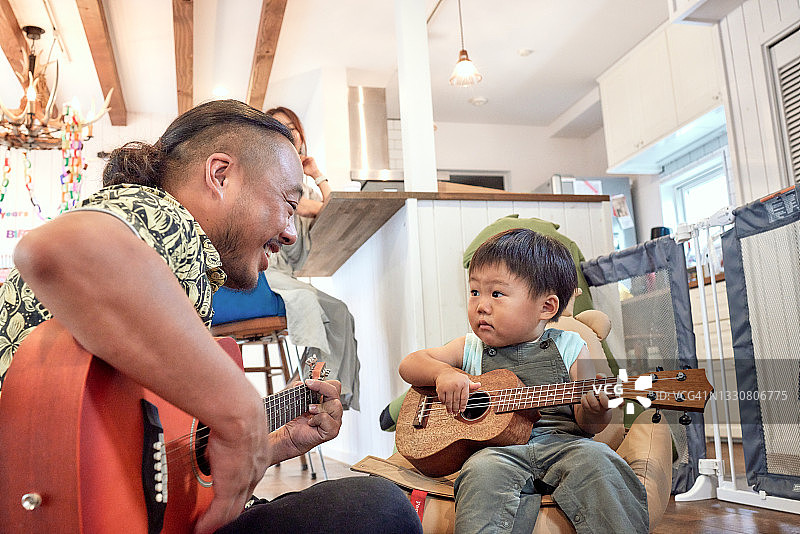 父亲和2岁男孩一起弹吉他图片素材