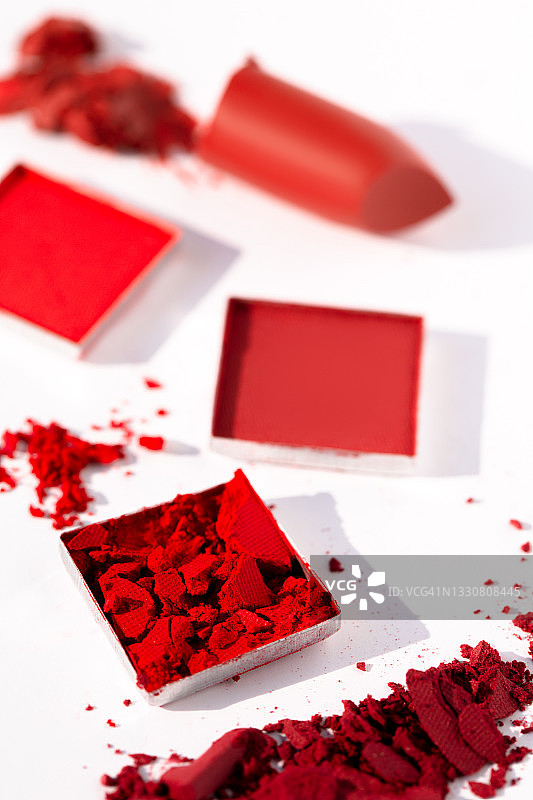 红色碎化妆腮红、眼影和口红，白色背景图片素材