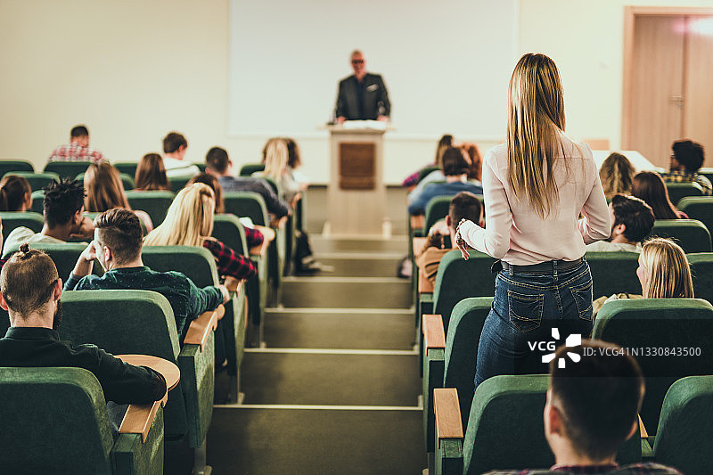 女学生在讲堂与老师交谈的背影图片素材