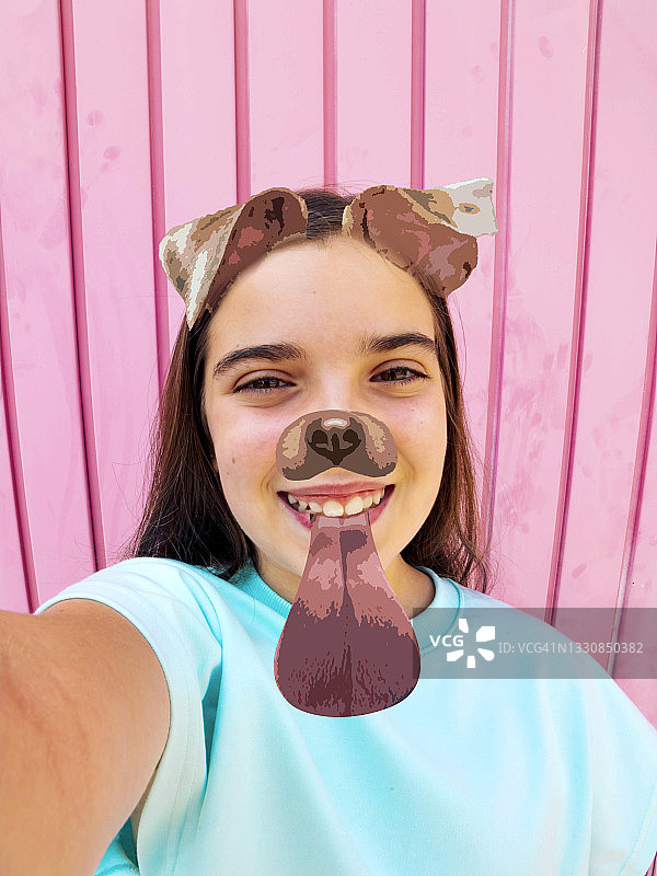 年轻女孩使用趣味狗脸滤镜拍竖版自拍照图片素材