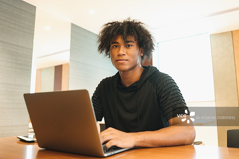 通过在线课程学习的年轻混血男子图片素材