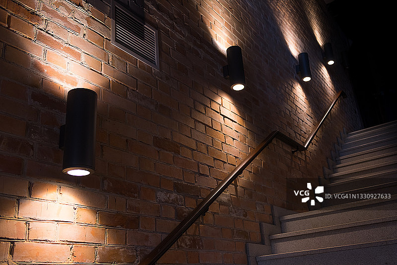 砖墙背景上的经典时尚壁灯。选择性聚焦，黄昏或夜晚开启的室外工作灯，文案区域图片素材