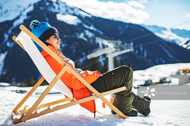 年轻女子在滑雪胜地休息图片素材
