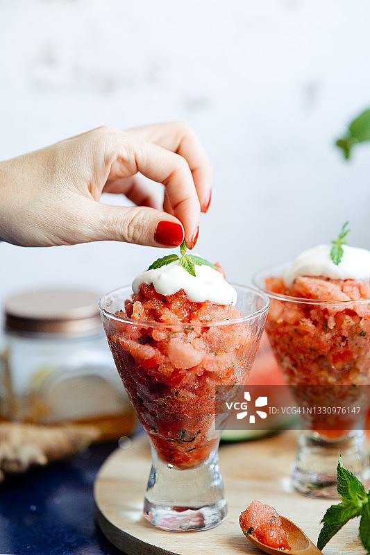 女人手持薄荷，放入西瓜姜汁希腊酸奶冰沙图片素材